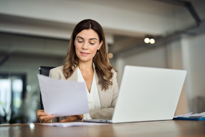 Gestora financeira, à mesa de trabalho, analisando o orçamento matricial da empresa