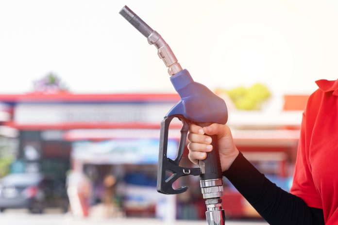 frentista segurando uma bomba de gasolina