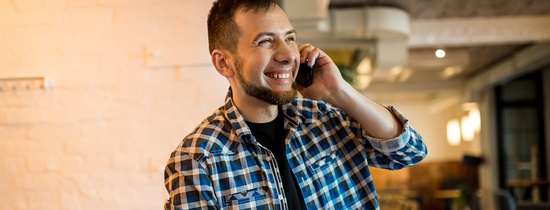 Homem sorrindo e falando no celular