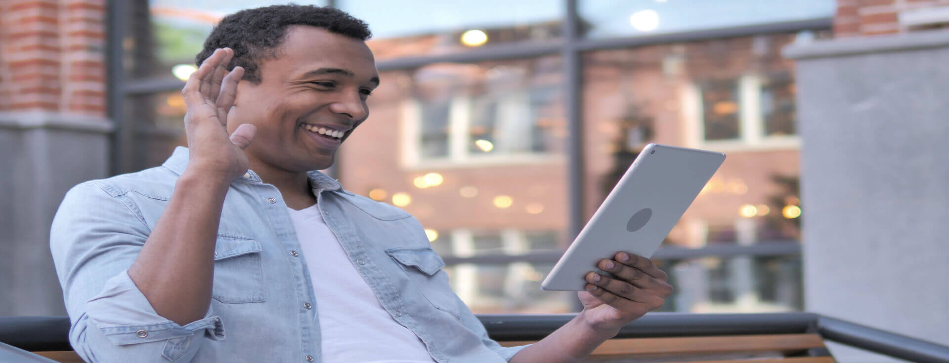 Homem sorrindo vendo tablet